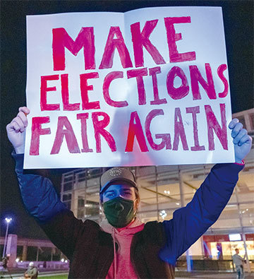 密歇根州11月4日凌晨暫停計票、又重新計票後，突然冒出13萬8000張投給拜登的選票，其他多個搖擺州都有相同情況。圖為密州的特朗普支持者要求公平選舉。（Seth Herald/AFP）