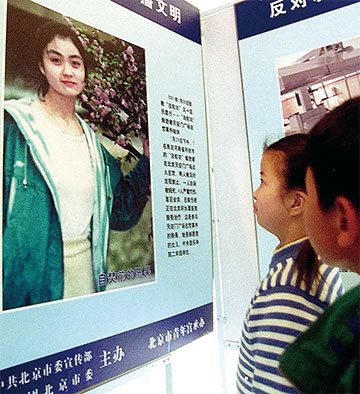 中共一手導演2001年1月23日除夕夜「天安門自焚」偽案，為鎮壓法輪功製造藉口。圖為2001年2月8日北京一展覽展示自焚者之一陳果照片，激起民眾的盲目仇恨。（STR /AFP）