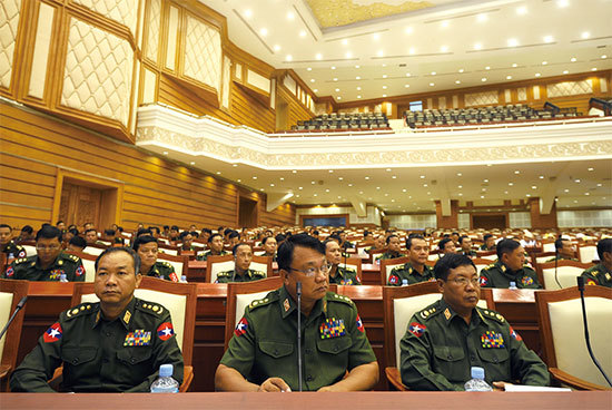 緬甸軍方2008年頒布的《憲法》有維護軍方利益的兩大條款：25％的議席不經選舉直接由軍方代表擔任，以及國防部、內政部和邊境事務部的部長由軍方代表擔任。（Soe Than Win /AFP）