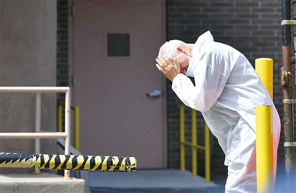 2020年4月7日，醫務人員在紐約布魯克林維科弗高地醫療中心外面擦了擦臉。（Angela Weiss / AFP）