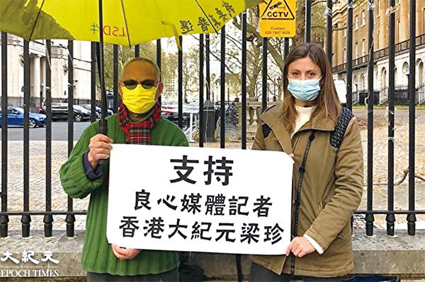 英國華人工黨聯合創辦人吳呂南博士（左）與支持香港爭取人權自由的國際組織NOW的薩爾瓦多（右）手持「支持良心媒體記者香港大紀元梁珍」的小橫額表達聲援。（文沁／大紀元）