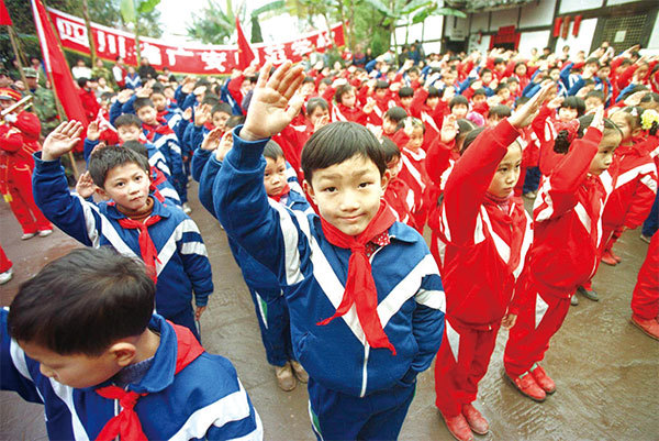 中共網羅中小學生強制入少先隊共青團，舉著拳頭在中共血旗前發誓把生命獻給中共。毒誓言不可以隨便發，所以要快做三退，主動擺脫中共的鉗制和利用。（Goh Chai Hin/AFP）