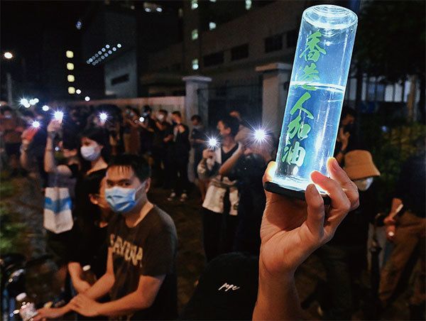 《蘋果日報》被迫關停，在香港傳媒環境中形成寒蟬效應，政治氣氛猶如暴雨將至。圖為2021年6月24日《蘋果日報》出報最後一晚，市民在雨中送別蘋果，亮起手機燈並高喊「香港人加油」。（宋碧龍／大紀元）