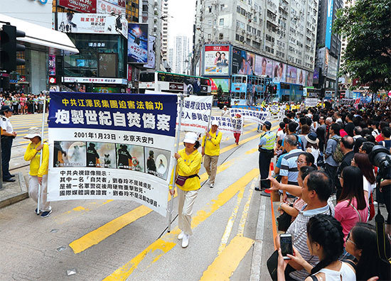 香港千名法輪功學員2018年7月22日在港島區舉行反迫害19周年集會遊行，呼籲停止迫害、法辦元凶。圖為橫幅：自焚偽案。（李逸／大紀元）