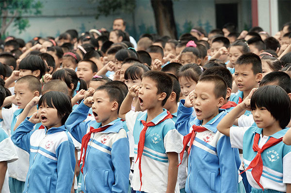 中共官方計畫在兩年左右的時間內，把民辦學校消除或者歸為官辦。圖為2014年，北京一所民辦民工子弟私立學校升旗典禮。（STR / AFP）