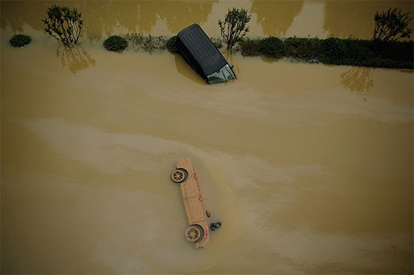 洪水淹沒鄭州市區，路上的車輛被洪水毀壞。（Noel Celis/AFP）