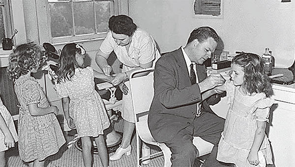 幾千年前中國就有天花病毒，近百年來在歐洲又出現，病毒並沒有徹底消亡，只是潛伏起來或轉移到其他地方。圖為1946年8月1日，朱厄爾嶺煤炭公司Tiernan博士，正在為學齡前兒童進行檢查和接種天花疫苗。（Ho / The National Archuves / AFP ）