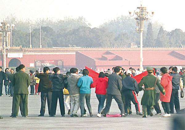1999年11月16日，北京天安門廣場，警察抓捕法輪功學員。（Stephen Shaver/AFP）