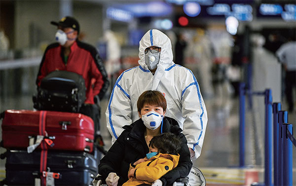 2020年3月19日，戴著口罩的旅客抵達上海浦東國際機場。（Hector Retamal/AFP）
