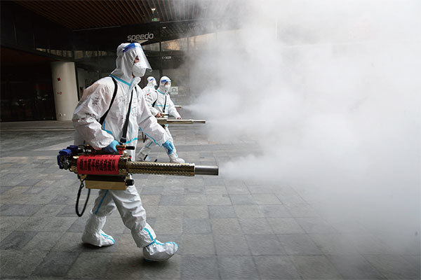 2022年1月11日，西安市衛生員穿著防護服在一個商場外面噴洒消毒劑。（STR/AFP）