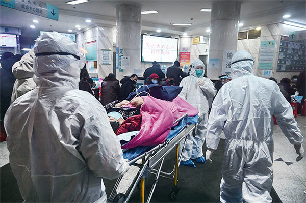 2020年1月25日，武漢紅十字醫院內醫護人員穿著防護服照顧染疫者。（Hector Retamal/AFP）