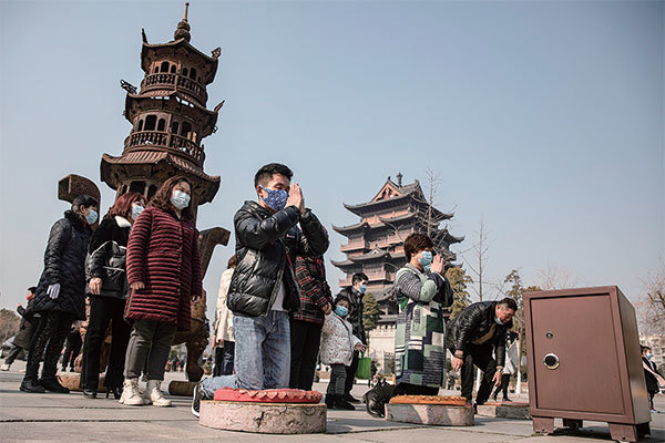 2022年1月1日，武漢市歸元寺裡戴著口罩祈禱新年平順的民眾。（Getty Images）