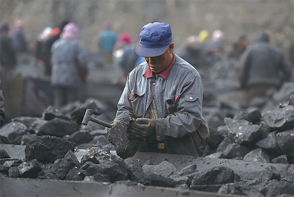 中國大陸的能源特徵是「富煤、貧油、少氣」，煤的碳排放量是所有化石能源裡最高的，致使中國單位能源的碳排放強度是世界平均水平的1.3倍。圖為2015年，一名工人在分揀煤炭。（Greg Baker / AFP）