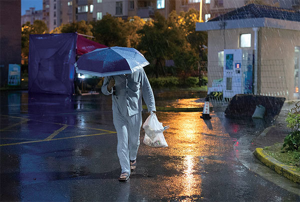 2022年4月13日，一名男子提著一袋袋食物走回上海一個住宅區。（Getty Images）