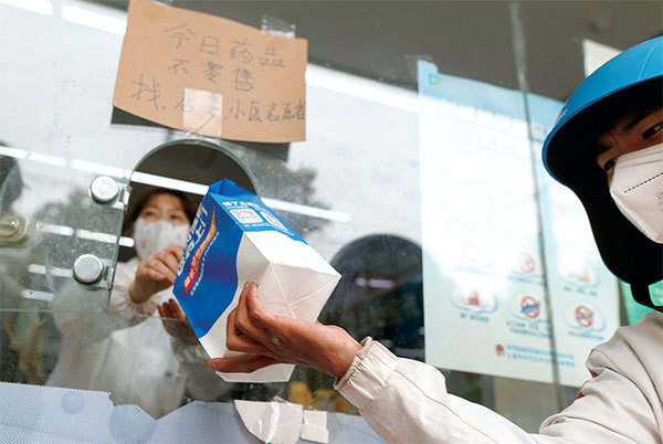 在上海，因被封控吃不上飯、看不了病的人比比皆是，甚至有人因而喪生。圖為2022年4月16日，一名送貨員從上海一家藥店拿到一袋藥。（Getty Images）