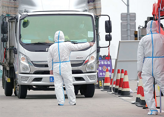 香港中文大學經濟團隊利用中國近200萬輛貨車定位的數據研判，封城會導致中國月損至少460億美元。圖為2022年3月16日山東煙台一貨車司機在高速公路檢測站。（STR / AFP）