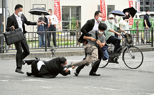2022 年7 月8 日，襲擊安倍的嫌犯山上徹也開槍後被保安人員制服。（Asahi Shimbun / AFP）