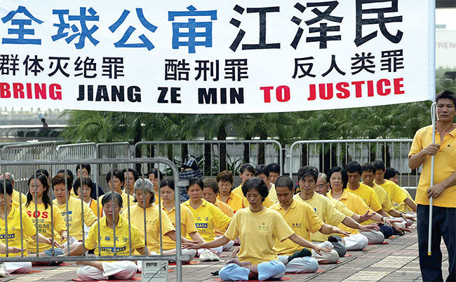 2009年11月，西班牙國家法院對江澤民等人以「酷刑罪」、「反人類罪」、「群體滅絕罪」等提起公訴。圖為2004年10月1日香港法輪功學員呼籲法辦江澤民。（Samantha Sin / AFP）