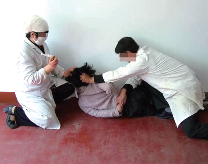 中共迫害法輪功學員的酷刑演示：施打毒針（注射不明藥物）。（明慧網）