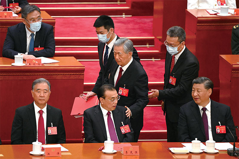 2022年10月22日，在中共二十大閉幕式上，前中共黨魁胡錦濤被強行「勸離」會場，汪洋（左一）木然僵坐。（Noel Celis / AFP）