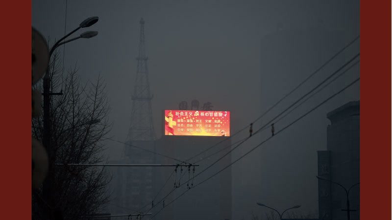 中共備戰打仗，中國經濟走向「紅色惡夢」。圖為北京重污染區的電子廣告牌上的共產黨宣傳口號。（Greg Baker / AFP）
