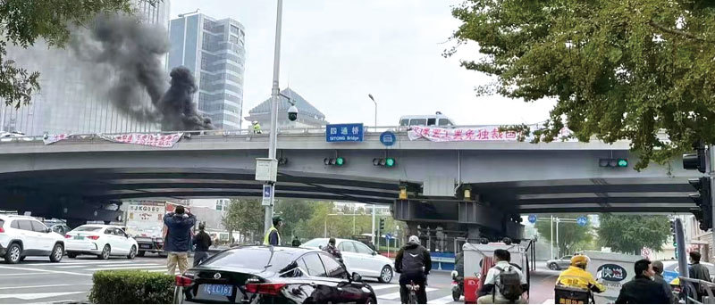 2022年10月13日，北京海淀區四通橋上出現兩條白底紅字的抗議標語。（推特）