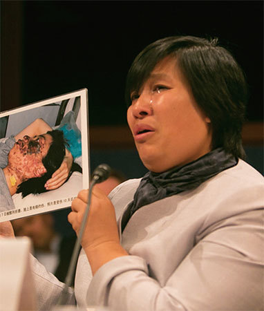 2016年4月14日，被迫害的法輪功學員尹麗萍在聽證會上舉起家鄉法輪功學員高蓉蓉的照片，指其被中共殺人滅口。（明慧網）
