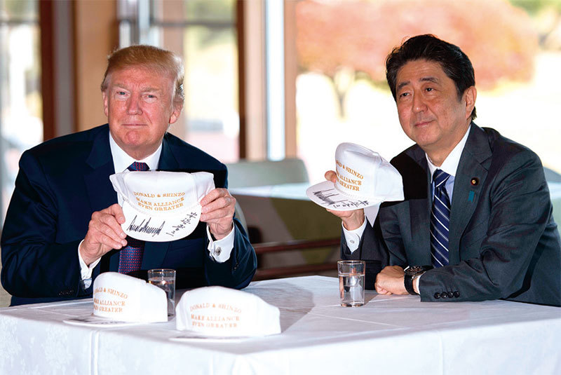 日本首相安倍陪川普打高爾夫球，並特別準備了兩個高爾夫球帽，上面寫著「唐納德和晉三：讓同盟更強大。」（Getty Images）