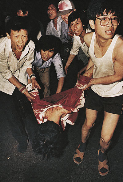 1989年6月4日凌晨，北京長安街，數名學生在搶救一名遭到中共軍隊開槍射殺的同學。（六四檔案）