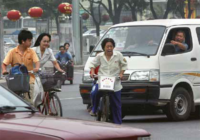 在中共的摧殘和變異之下，中國人不光心靈變得荒蕪、粗礪，連外形和表情都變得不一樣了。圖為北京一名司機與違規的自行車婦人當街互罵。（AFP）