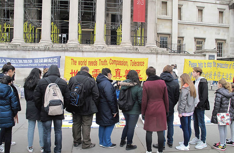 3月24日，英國法輪功學員慶祝三億中國人三退，吸引民眾駐足觀看、了解真相並簽名反迫害。（明慧網）