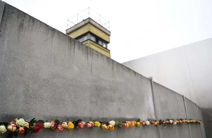 很多德國人反對把中共送的馬克思雕像擺出來，特別是飽受共產主義折磨的原東德人更是對馬克思滿懷怨恨。圖為2014年紀念柏林牆倒塌，柏林牆的一個保留區域裝飾著玫瑰花。（AFP）