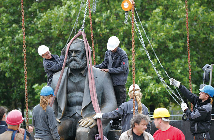 中共在馬克思200年生辰日舉行紀念活動，利用馬克思這個殼把自己裝扮起來，然如此形徑只會讓民眾更加認清其邪惡本質。圖為2010年9月8日，德國工人正在移除柏林的一座馬克思雕像。（AFP）