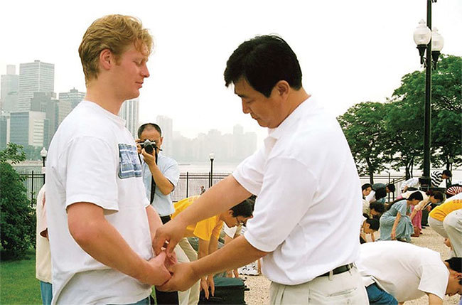 1995年3月，李洪志大師遠赴法國，開始海外傳功。圖為李先生在1999年芝加哥為學員糾正煉功動作。（明慧網）