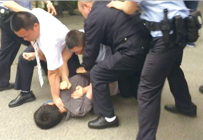 Now TV新聞臺攝影記者徐駿銘被警察及便衣人員按倒在地。（謝燕益之妻袁姍姍供圖）