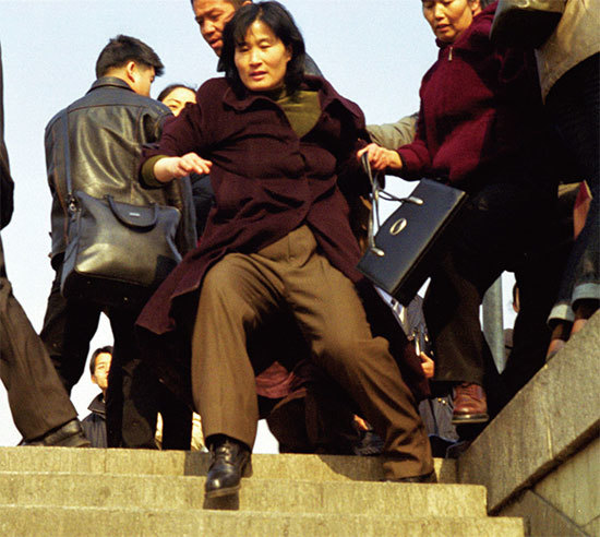 2000年的第一天，他的妻子獨自去北京上訪，在天安門被綁架、關押。圖為法輪功學員被強行拖向天安門廣場的地鐵。（Getty Images）