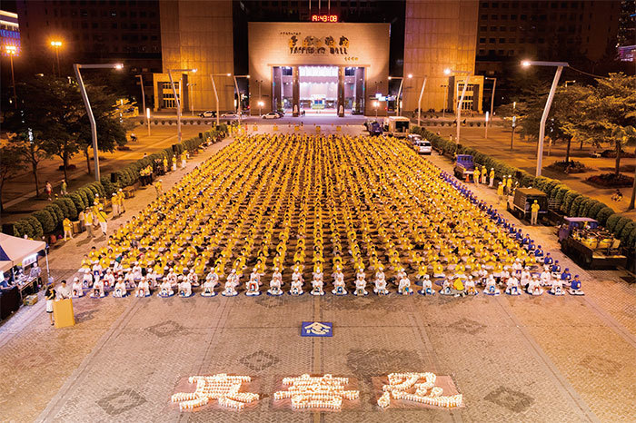 7月14日法輪功學員在臺北市政府廣場前舉辦反迫害19周年燭光悼念活動。（大紀元）