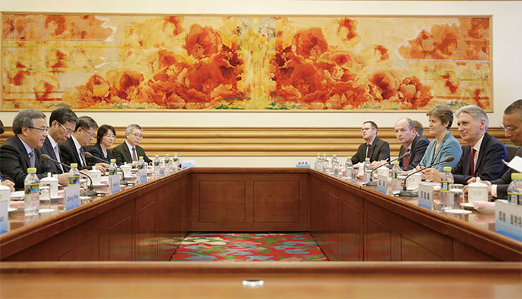 胡春華（左前）6月27日首次以中英經濟財金對話中方牽頭人身分，在中南海會見了英國財政大臣、對話英方牽頭人哈蒙德（右前）一行，這一安排也引起一些猜測。（AFP）