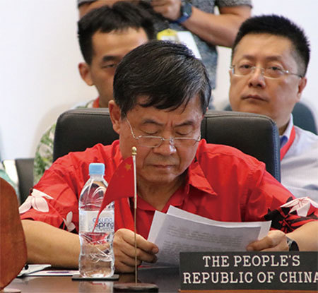 今年9月3日「太平洋島國論壇」時，中共代表杜起文（著紅衣）無視規定堅持發言，被制止時還起身揮舞桌牌鬧場。（Getty Images）