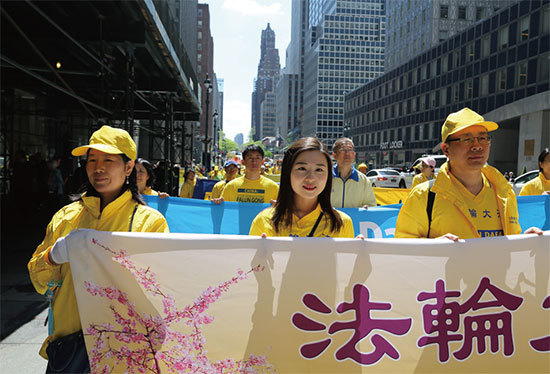 5月16日，李扶搖（中）和父母親在慶祝法輪大法弘傳27周年曼哈頓大遊行中。（施萍／大紀元）