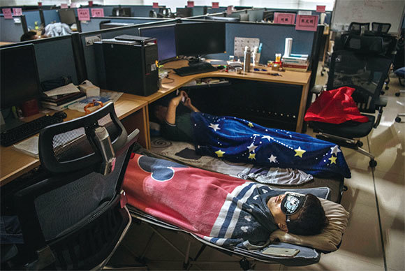 華為深圳總部員工桌子底下都有一個被褥，午飯後小睡，隨後他們要工作到晚上10點。（Getty Images）