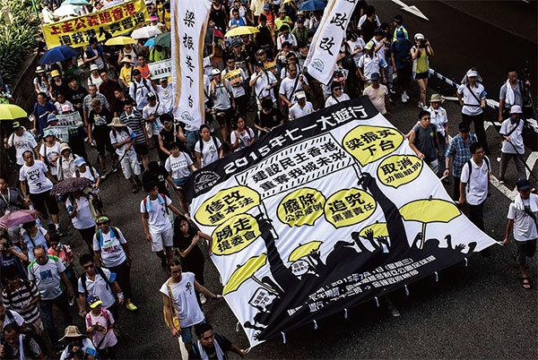 2014年，香港發起一場爭取真普選的集會，最終演變成「佔中」，前特首梁振英製造開槍流血鎮壓。習近平不但不讓梁連任還要收拾他。圖為2015年7月1日香港大遊行要求梁振英下臺。（Getty Images）