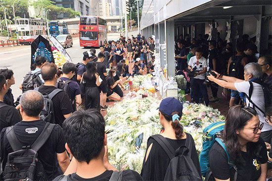 6月16日上午，香港市民紛紛到太古廣場入口，將白色鮮花、悼念字條等獻給死者。（孫青天／大紀元）
