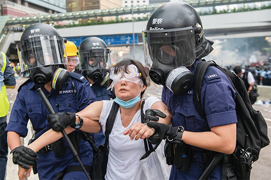 6月12日，香港「反送中」示威衝突升高，警方暴力抓走一位女士。（Getty Images）