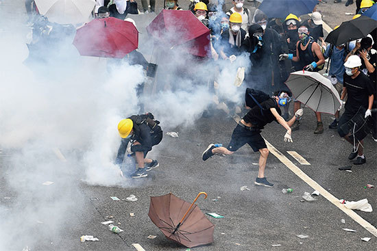 6月12日，警方發射催淚彈驅趕民眾。圖為市民被催淚彈射傷送醫。（AFP）