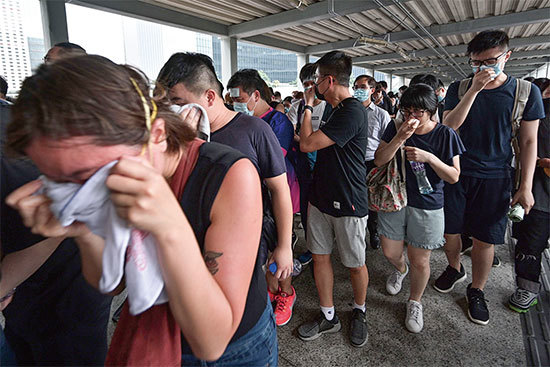 2019年6月12日，香港「反送中」示威衝突升高，警方發射催淚彈驅趕，造成民眾眼鼻不適。（AFP）