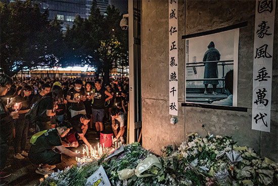 香港男子梁先生15日「反送中」期間，登上金鐘太古廣場樓頂平臺，危險處站立約5小時後，不幸墜地身亡。圖為6月16日民眾為其燭光悼念。（Getty Images）