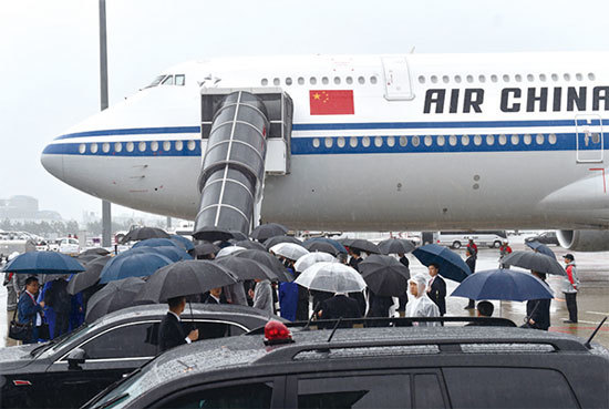 習近平的專機抵日時，適逢關西機場一帶下起大雨，機場意外出現雨傘「遍地開花」的景象，令人聯想到2014年香港的「雨傘革命」。這似乎不是好預兆。（AFP）