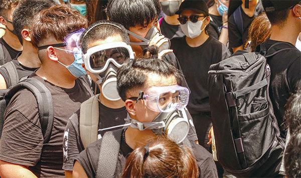 港人已從歷次的抗議活動中吸取經驗，許多人會以帽子和口罩遮住面部，以免身分暴露，同時也可以對抗催淚瓦斯。（余鋼／大紀元）