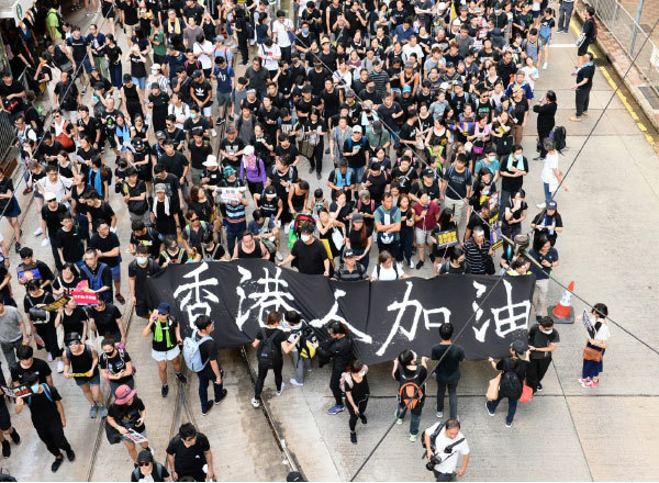2019年7月21日，香港，民陣發起的反送中遊行隊伍中，市民拿著寫有「香港人加油」的標語為香港人打氣。（宋碧龍／大紀元）
